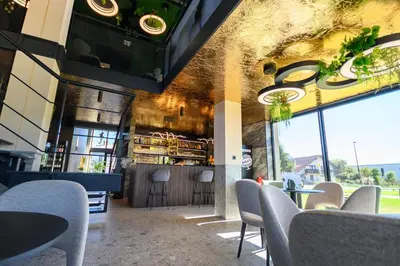 a restaurant with chairs and tables and a bar at Hotel Adore in Ljubljana
