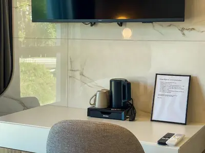 a desk with a tv and a chair on it at Hotel Adore in Ljubljana