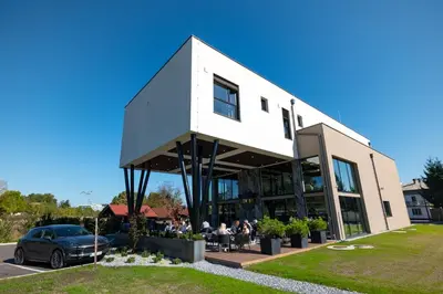 a white building with people sitting outside of it at Hotel Adore in Ljubljana