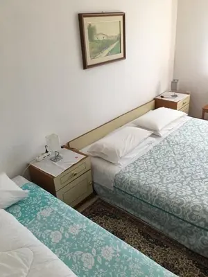 a hotel room with two beds and a picture on the wall at B&B LOKEV Lipica HostelSezana in Lokev