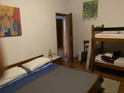 a room with two beds and a bunk bed at B&B LOKEV Lipica HostelSezana in Lokev