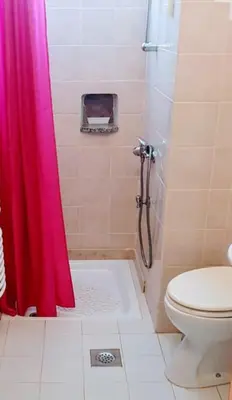 a bathroom with a shower with a pink shower curtain at B&B LOKEV Lipica HostelSezana in Lokev