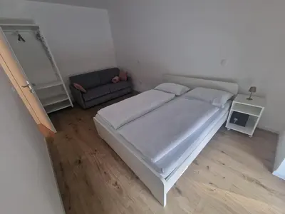 a small bedroom with a bed and a couch at Antica Dolina in Postojna