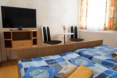 a bedroom with two beds and a flat screen tv at Vila Šiftar in Moravske Toplice