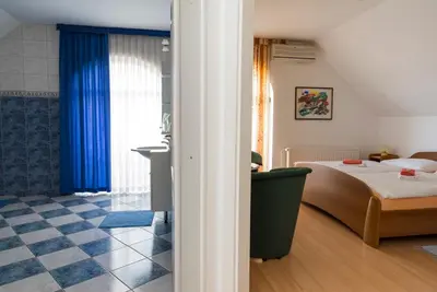 a bedroom with a bed and a blue curtain at Vila Šiftar in Moravske Toplice