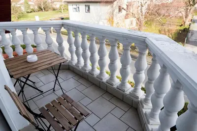 a balcony with a table and a white railing at Vila Šiftar in Moravske Toplice