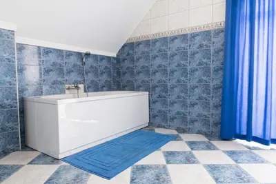 a bathroom with a tub and a blue shower curtain at Vila Šiftar in Moravske Toplice