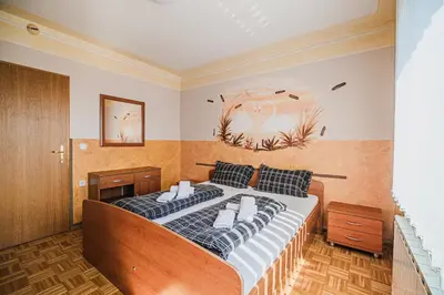 a bedroom with a large bed with black and white pillows at Guesthouse Siva Čaplja in Videm pri Ptuju
