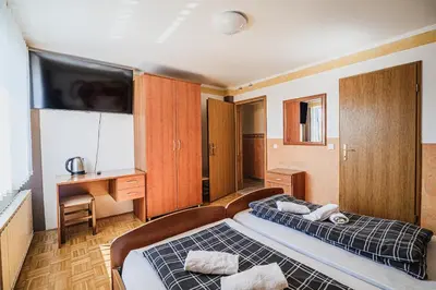 a bedroom with a bed and a desk and a television at Guesthouse Siva Čaplja in Videm pri Ptuju