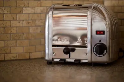 a toaster is sitting on the floor next to a brick wall at Room for 2 - Pri B'zjak in Kobarid