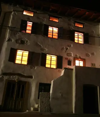 a building with lit up windows in the night at Room for 2 - Pri B'zjak in Kobarid