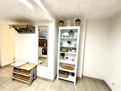 a room with a mirror and a table and a shelf at New comfortable and cute one-room apartment of 33 m2 in Ljubljana