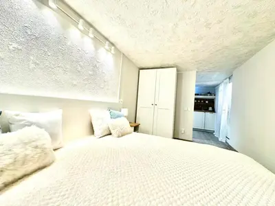 a bedroom with a large white bed with pillows at New comfortable and cute one-room apartment of 33 m2 in Ljubljana