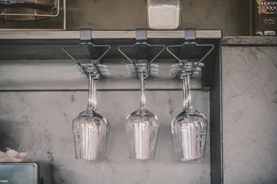 four wine glasses are hanging on a shelf at Beg Residence in Rogaška Slatina
