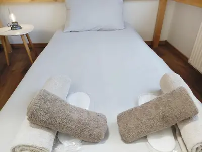 a white bed with two towels on top of it at SiJu loft bed in Postojna
