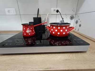 two red and white polka dot cups sitting on a stove at SiJu loft bed in Postojna
