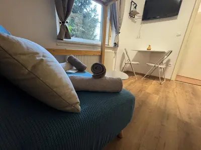 a living room with a couch and a table at SiJu loft bed in Postojna