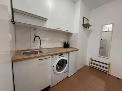 a kitchen with a washing machine and a sink at SiJu loft bed in Postojna