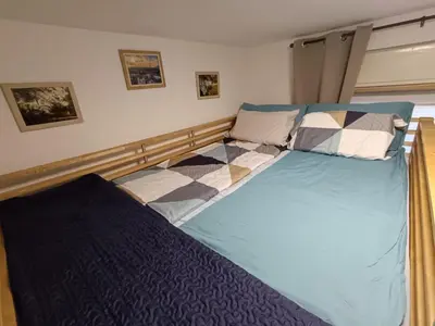 a bedroom with a large bed with checkered sheets at SiJu loft bed in Postojna