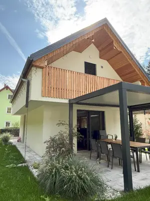 a house with a patio with a wooden roof at Charming house in Gozd Martuljek in Gozd Martuljek