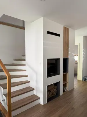 a living room with stairs and a fireplace at Charming house in Gozd Martuljek in Gozd Martuljek