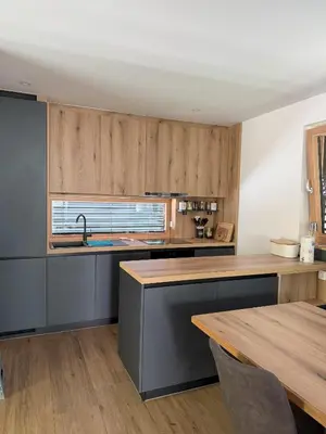 a kitchen with wooden cabinets and a wooden table at Charming house in Gozd Martuljek in Gozd Martuljek