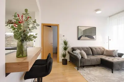 a living room with a couch and a vase of flowers at Apartma Masada in Maribor