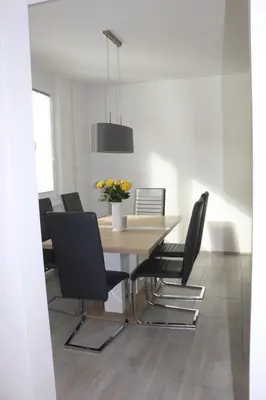 a dining room with a wooden table and black chairs at Apartment Valis in Velenje