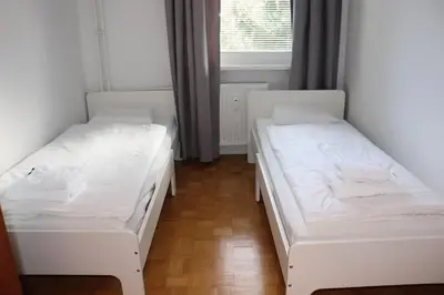 two beds in a room with a window at Apartment Valis in Velenje