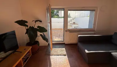 a living room with a couch and a plant at Ljubljana Garden Apartment - Free Parking in Ljubljana