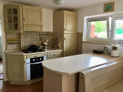 a kitchen with white cabinets and a counter top at Ljubljana Garden Apartment - Free Parking in Ljubljana