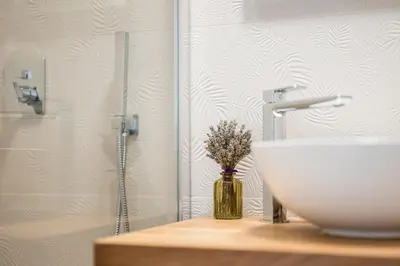 a bathroom with a sink and a vase with flowers at Villa Sofija in Kojsko