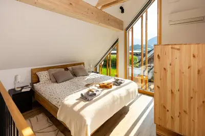 a bedroom with a bed and a large window at Cherryhood Chalet in Bohinj