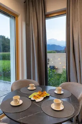 a table with two cups and plates of food on it at Cherryhood Chalet in Bohinj