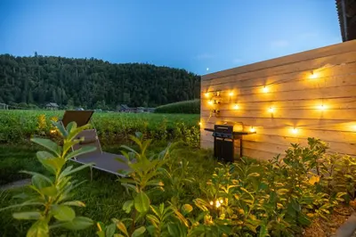 a bench in a garden with lights on it at Cherryhood Chalet in Bohinj
