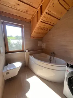 a large bathroom with a tub and a window at Ethno holistic village Apače in Apače