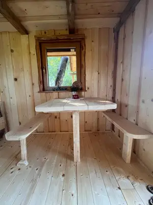 a room with two benches in a cabin with a window at Tree house - Ethno holistic village Apače in Apače