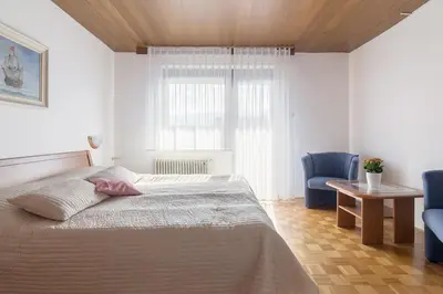 a bedroom with a bed and two blue chairs at Apartments Fine Stay Bled in Bled