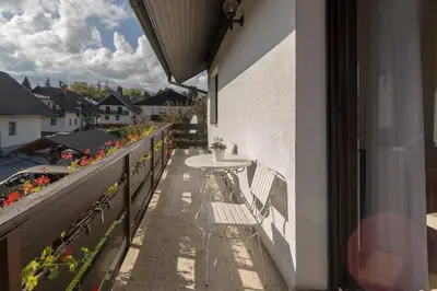 a table and chairs on the balcony of a building at Apartments Fine Stay Bled in Bled