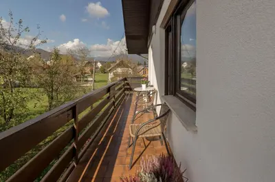 a balcony with two chairs and a table and a window at Apartments Fine Stay Bled in Bled