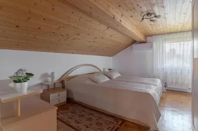 a bedroom with a bed and a wooden ceiling at Apartments Fine Stay Bled in Bled