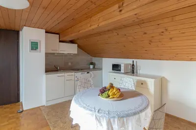a kitchen with a table with a bowl of fruit on it at Apartments Fine Stay Bled in Bled