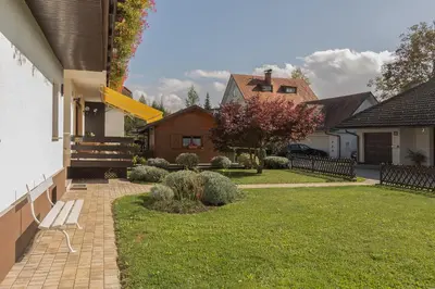 a house with a lawn with a bench in the yard at Apartments Fine Stay Bled in Bled