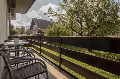 a balcony with two chairs and a table on a fence at Apartments Fine Stay Bled in Bled