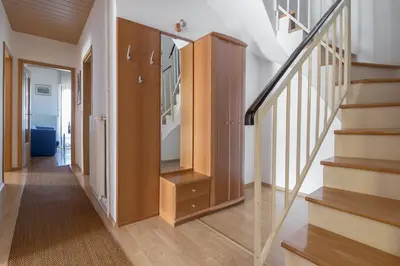 a hallway with stairs and a wooden cabinet at Apartments Fine Stay Bled in Bled