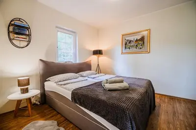 a bedroom with a bed and a lamp and a table at Apartment Luna 65 in Podčetrtek