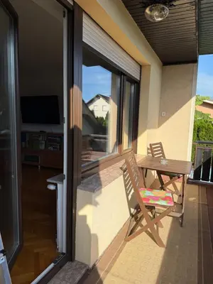 a patio with a table and a chair on a balcony at Altitude50 apartment Domžale in Domžale