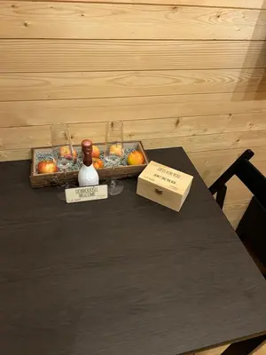a table with a tray of apples and a bottle of wine at La - Mai Glamping in Žetale