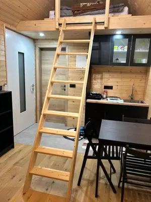 a ladder leading up to a loft bed in a kitchen at La - Mai Glamping in Žetale