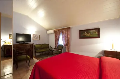 a bedroom with a red bed and a living room at The Blue House in Tolmin